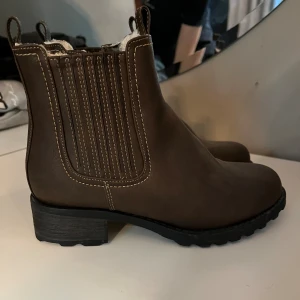 Skor - Hej! Säljer ett par bruna boots som aldrig är använda. Storlek 38
