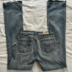 Lågmidjade jeans med coola fickor - Vintage lågmidjade jeans med coola bakfickor och sömmar. Bootcut/straight i benen! Väldigt true religion liknande.  W26