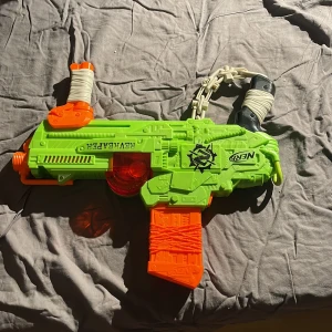 Nurfgun - En stor nurfgun som skjuter många skott samtidigt, den har med ett magg där man lägger skotten i