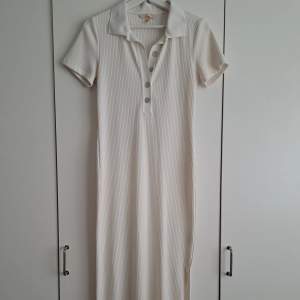 Fin ribbad vit lång klänning. Passar de som är mellan 165-175 cm lång.