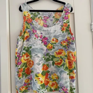 Blommigt linne i viskos fr Nouvelle i strl 42 - Blommigt linne i viskos fr Nouvelle i strl 42.  Endast använt ett par gånger och är i fint begagnat skick.  Mått Över bröstet: ca 53 cm Längd från axeln och ner: ca 65 cm  100% viskos