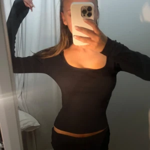 FIGURNÄRA TOPP - Säljer en svart långärmad topp i storlek XS. Toppen är tight och har en rund halsringning. Perfekt för både vardag och middag! Kan ha åt två håll👚