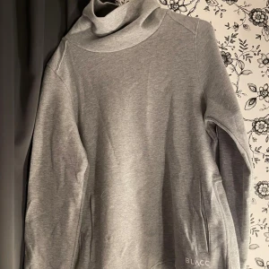 Grå polotröja från Blacc - Säljer en snygg och bekväm grå polotröja från Blacc. Tröjan är perfekt för kyligare dagar och har en normal passform. Den är tillverkad i ett mjukt och skönt material som håller dig varm. Perfekt för både vardag och träning!