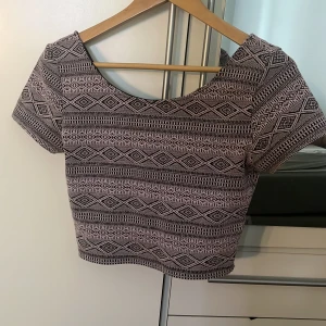 Topp - Lila/svart topp från HM. Väldigt små tecken på användning, gott skick. Croppad i modellen 