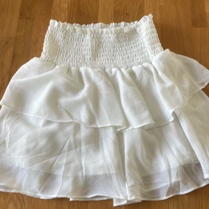 Vit volang kjol - Lite stor i storleken. bra skick förutom en liten fläck på sidan av kjolen. Har inte använts mycket