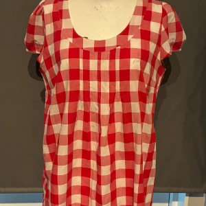 Röd och vit rutig klänning från Number One - Säljer en superfin röd och vit rutig klänning från Number One. Den har en rund halsringning och korta ärmar. Perfekt för sommarens alla fester eller en mysig picknick i parken. Klänningen är i bomull och känns väldigt bekväm att ha på sig. Passformen är normal och den är i nyskick. 🌸