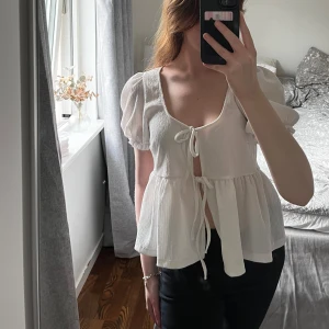 topp - texturerad vit topp med kort puffärm och knytstängning framtill. använd endast 1 gång☺️