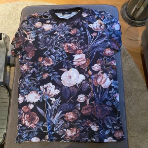 Blommig T - shirt - En mörk blommig t -shirt i fint skick. 