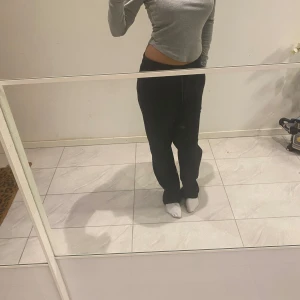 Grå långärmad tröja - En enkel och stilren grå långärmad tröja. Tröjan har en rund halsringning och är något croppad i modellen.