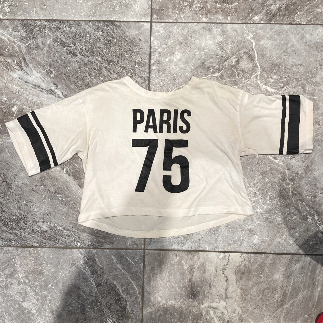 Vit topp med texten 'PARIS 75'