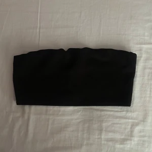 Svart tubtopp - En enkel och stilren svart tubtopp. Toppen är ärmlös och har en tight passform.