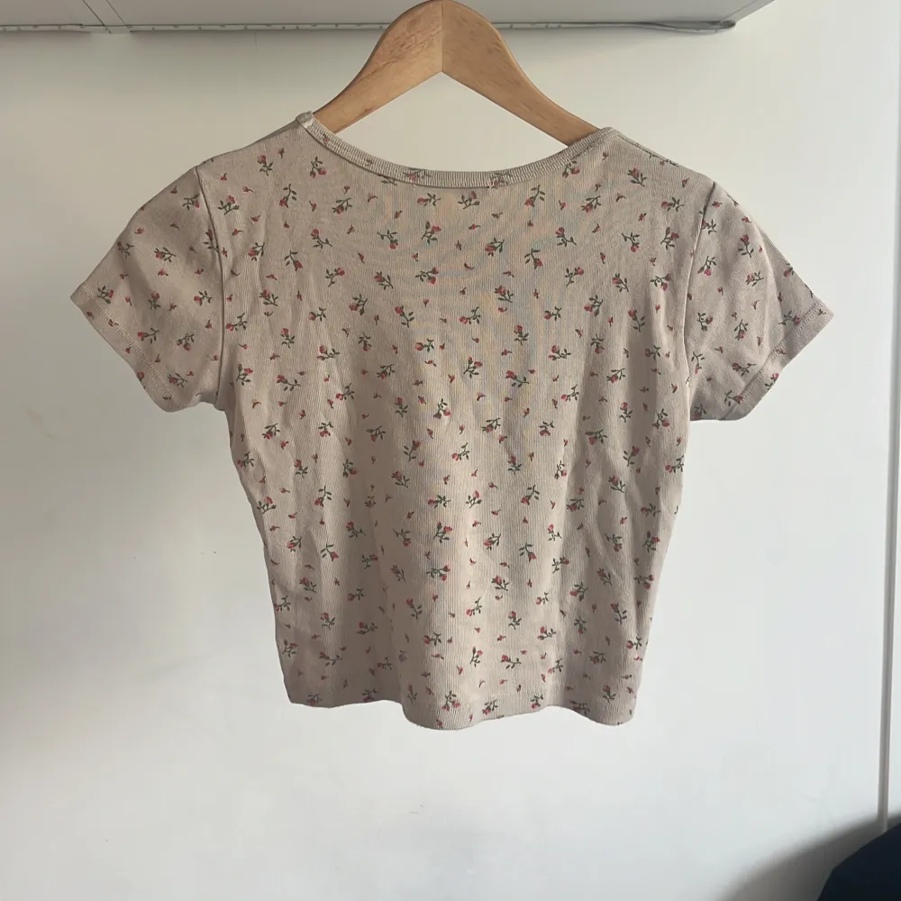 Säljer denna fina ljusrosa T-shirten med blommor på från brandy Melville i storlek S/M. Ganska bra skick, kan diskutera pris💕. T-shirts.