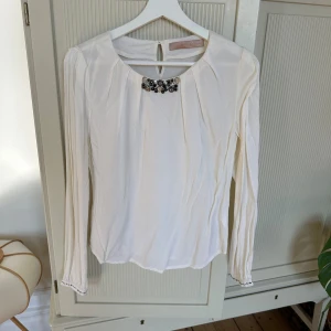 Cremevit blus i Viscosematerial, Culture - Fin blus i mycket fint skick. Fina detaljer. Veck på axklarna. Väldigt skönt material. Normal i storleken (34)