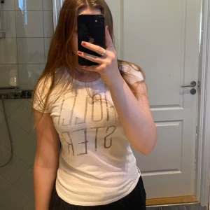 Vit Hollister t-shirt - Normal i storleken. Har silvrigt & gulligt tryck.