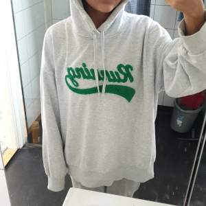 En bekväm grå hoodie med texten 'Running' i grönt på framsidan. Hoodien har en justerbar huva med gråa snören och långa ärmar. I storlek M, jätte skön. Säljer pga att den är för stor💓 Köpt på H&M. Inga defekter. DM för mer bilder.