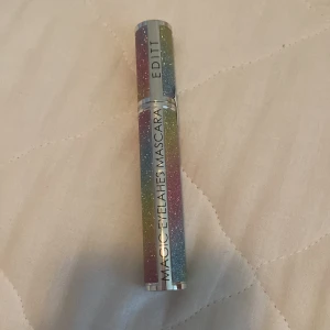 Magic Eyelashes Mascara - En mascara med en glittrig, flerfärgad förpackning från märket Edit. Produkten är designad för att ge magiska ögonfransar.