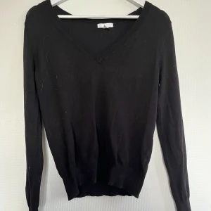 Svart stickad tröja - Svart tunn stickad tröja med V-ringning från H&M men köpt second hand men aldrig använd. Jätte bra skick.
