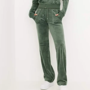 Gröna mjukisbyxor - Ett par gröna mjukisbyxor i ett mjukt och bekvämt material. Byxorna har en hög midja och raka ben. De har också fickor på sidorna. Juicy Couture, jättebra skick