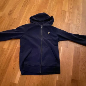 Zip upp - Säljer en lyle and scott zip i storlek 14-15 år. Tröjan har ett litet hål i armhålan på vänster sida. Annars är den väldigt fräsh 
