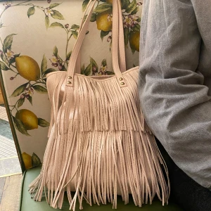 Frans väska - En ljusrosa väska med fransar på sig i jättebra skick!