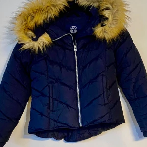 Jättesnygg täckjacka tjej - Mörkblå jättesnygg täckjacka med pälsförsedd luva. Obetydligt använd. Hämtas, Gamla Råslätt, endast swishbetalning