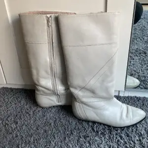 Gråa boots med liten klack, dragkedja, fodrade, går över vaden, inga hål i sulan men slitna och syns att dom är använda går dock att fixa lätt med lite touch up 