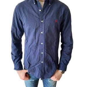 Ralph Lauren skjorta - En mörkblå Ralph Lauren skjorta i storlek m.  Bra skick, inga defekter. Modellen är 185 cm. Nypris 1500kr