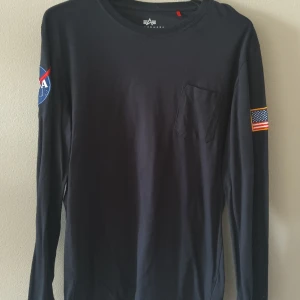 Alpha Industries Long Sleeve T-shirt Nasa - Fint skick med bröstficka och broderat tygmärken på båda armarna!  Storlek M