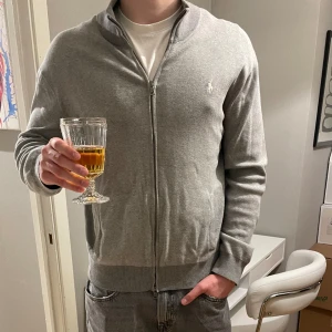Ralph lauren zip hoodie - Hej säljer denna gråa Ralph lauren zip tröja. Skicket är fint utöver en liten defekte vid ena fickan (se bild 2) storleken är L Och han på bilden är 189cm lång. Skriv vid fler bilder eller funderingar!