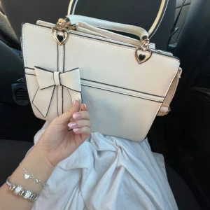 Väska  -  Beige väska med rosett  Guld detaljer 