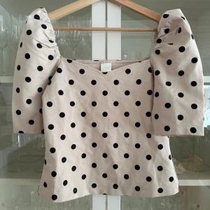 Prickig topp med puffaxlar - Superfin beige svart prickig topp med puffaxlar. Från H&M i storlek S.🥰
