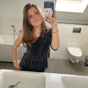 Glittrig topp - Jätte snygg glitter topp med bar Axel på ena sidan. Mycket snygg och passar bra till många tillfällen 