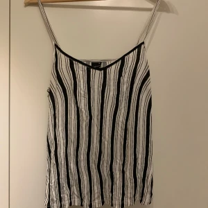 Randigt linne - Svart och vit randigt linne från ginatricot, har använts ett par gånger, skönt och tunt linne perfekt till varmare dagar, v ringning och spaghetti band. Är skrynklig på bilden men går lätt att fixa. Storlek xs.