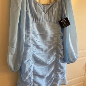 Nelly klänning - En Klänning som är oanvänd med prislapp kvar beställd från Nelly i storlek 38 , i en vacker ljusblå färg , säljer nu för 100 kr