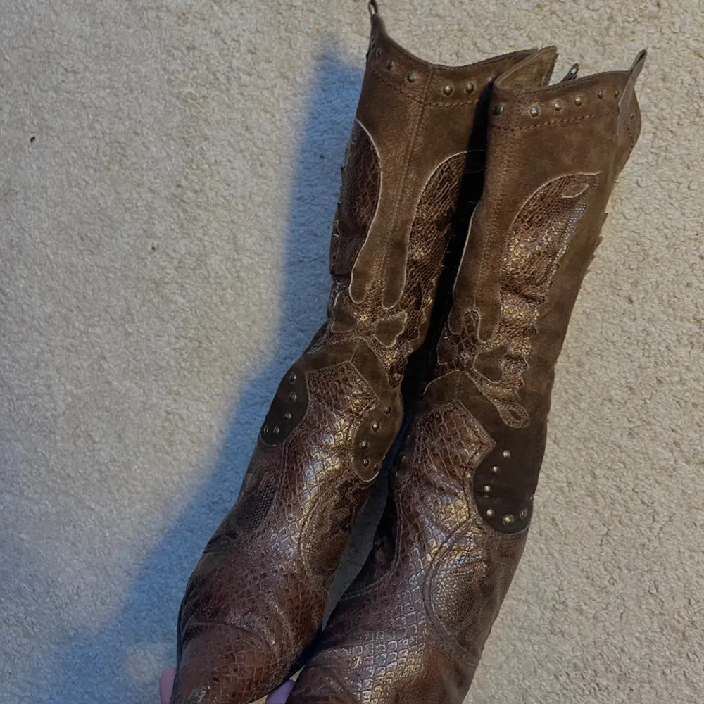 Unika cowboyboots i mocka o läder 🤎Har balla detaljer runt o hela skorna🤎Använt varsamma men har lite slitage som syns på bilderna🤎Är i storlek 40 men skulle säga 39 då de är så spetsiga vid tån så de blir mindre🤎. Skor.