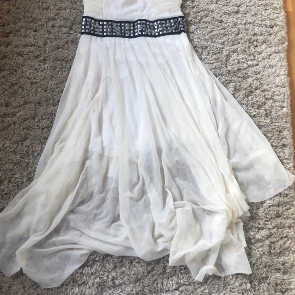En vit fin somrig klänning med nitar runt midjan.Färgen har blivit lite mer gulaktig på de flesta ställena.Säljer då den inte sitter så bra på mig (S) Det är ett stretchigt material och har inga band. . Klänningar.