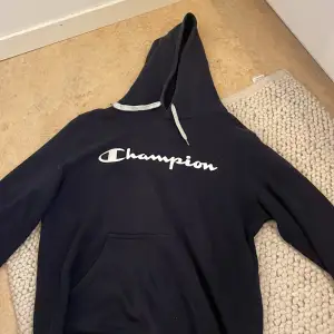 Mörkblå champion hoodie med text på bröstet