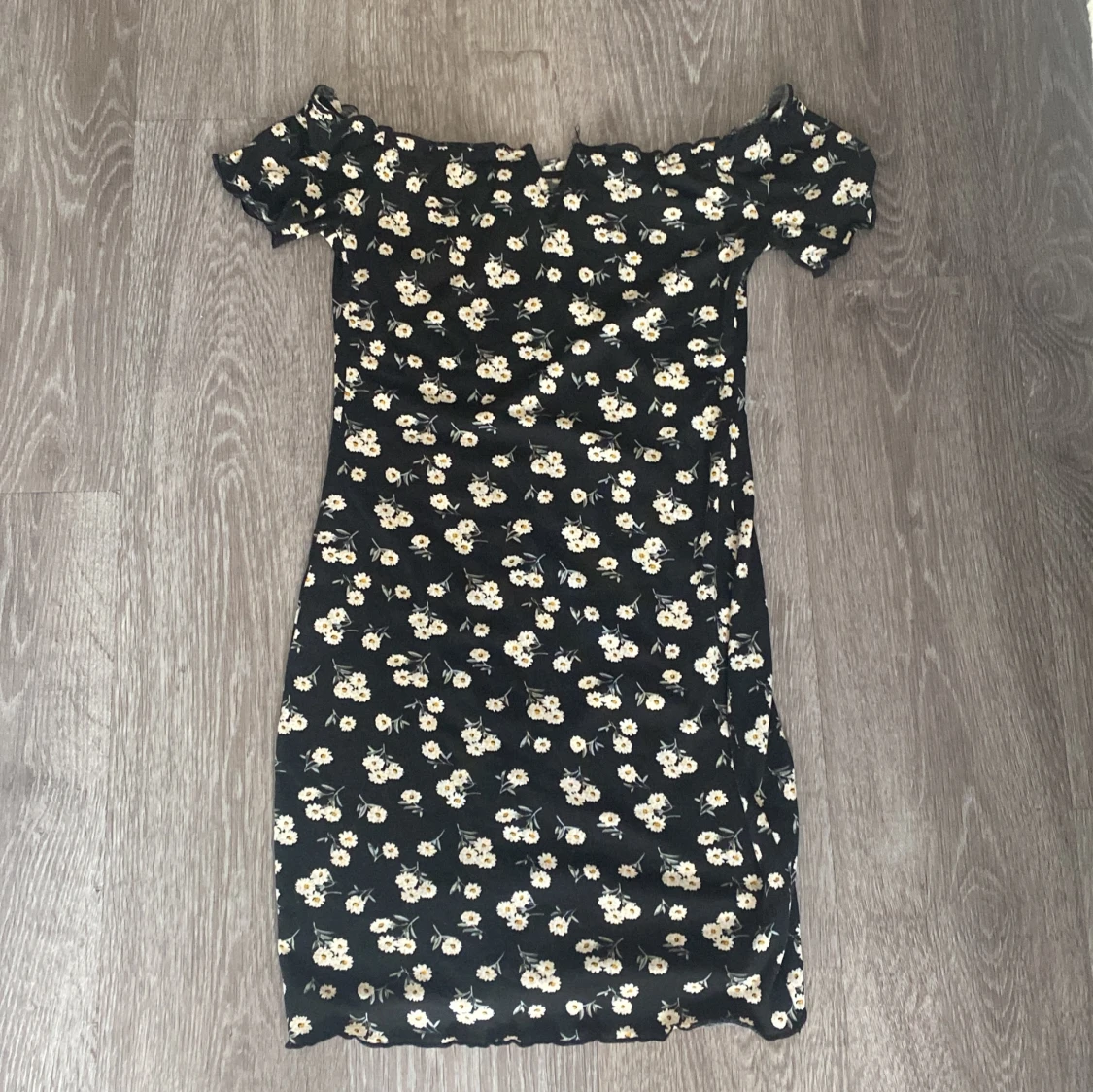 Fin blommig klänning har en liten v vid brösten