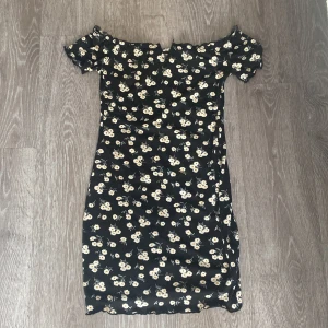 Fin blommig klänning har en liten v vid brösten - 10/10