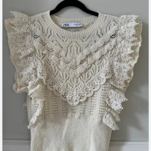 Virkad topp med volang  - Topp från Zara som inte säljs längre. Använd fåtal gånger, bra skick. Passar som S och M. Är en blandning mellan vit och beige. 
