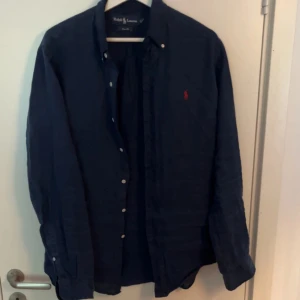Ralph lauren linne skjorta - Storlek M | skick 9/10, gott som nytt | Marinblå linne skjorta från Ralph lauren | ny pris är 1500kr | perfekt att ha inför sommaren | Priset är inte huggit i en Sten |