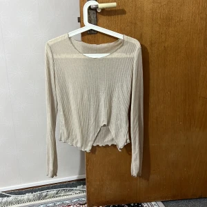 Topp - Beige topp med slit i bra skick❤️ Liten i storleken, passar därför XS, S, M! Svalt material, kan enkelt layeras snyggt med andra plagg! Hade passat bra i kombination med tex gröna eller bruna färger😍