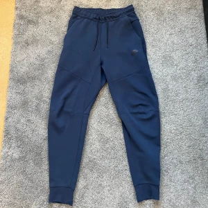 Nike tech byxor  - Snygga Nike tech byxor marinblå färg, Storlek S modellen på bilden är 1,70cm lång, inga defekter  Om du har frågor skriv på dm! 