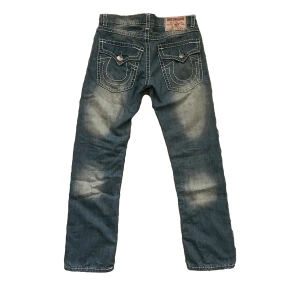 True Religion jeans - Säljer pga att de inte längre faller mig i smaken. Knappt använda i riktigt bra skick. Ingen skada.  Längd: 106cm Benöppning: 20cm Waist: 44cm
