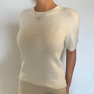 Stickad tshirt - Vit stickad tshirt från H&M, använd ca 1 gång, köpt i Madrid i december. Är 164cm.