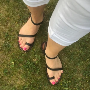 Sandaler svart Stl 38 - Sköna sandaler med snygga och praktiska läderremmar som håller foten på plats.  Längden på Stl 38 är 25 cm, bredd 9 cm. Danska märket Unmade. Nypris 799kr. Djur- och rökfritt hem. Kolla gärna övriga annonser.