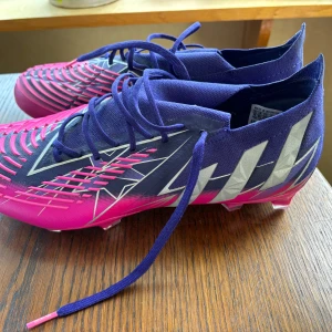adidas Predator Edge .1 Low FG Champions Code - Lila/Silver/Rosa - Fotbollsskor us11 är en 45a och dom passar perfekt dom är nyskick använda 1 gång inomhus!