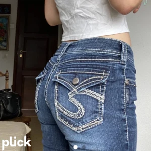 lågmidjade y2k bootcut jeans - supersnygga lowrise bootcut jeans med silverdetaljer på fram-bakfickorna🌟🌟sjukt bekväma då dom har lite stretch💗💗kan vara y2k men funkar lätt med stockholmsstil mm😁😁 storlek w28 så passar nog nån med xs/s/34/36!! skriv om det är något💗💗
