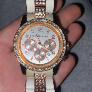 Michael kors klocka  - Säljer denna otroligt fina Michael kors klockan, den är i rosé guld och fungerar felfritt behöver bara batterier. Den är i bra skick, den är använd och en diamant saknas som ni kan se på 1/3 bilden. Kostar runt 2000kr, SÅKLART äkta!