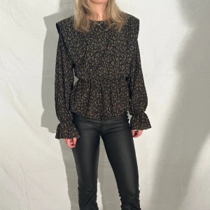 mönstrad blus - Grön och svart leopardmönstrad tunn blus. Resårband i midjan och ärmar med detaljer.  Passar xs-m tjejen på bilden har i vanliga fall xs